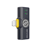 Hollyland Lark M2 shine charcoal Lightning receiver dongle angled view: black USB adapter with Lightning plug (yellow accent), Hollyland logo, green TX1 and TX2 status LEDs on, coiled cable, dual-channel wireless lavalier receiver for iOS