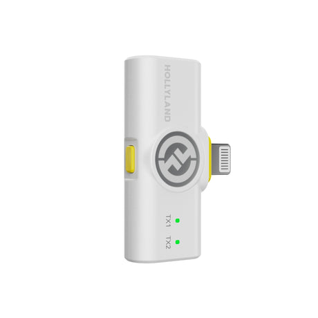 Hollyland Lark M2 shine white Lightning receiver side view plugged into iPhone: white USB-C to Lightning dongle with yellow power button, Hollyland logo, green TX1 and TX2 status LEDs lit, connecting wireless lav mics to iOS devices