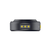 Hollyland Lark M2 shine charcoal TX wireless lavalier transmitter bottom view: black round housing with three yellow charging contacts for magnetic cradle, slim profile highlighting USB-C compatibility and compact battery design