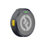 Hollyland Lark M2 shine charcoal TX wireless lavalier transmitter angled top-front view: round black unit powered on with green pairing LED illuminated, yellow power button, Hollyland logo, mesh grille visible, ideal for podcasting and video production