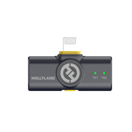Hollyland Lark M2 shine charcoal Lightning receiver plugged into iPhone: black USB-C to Lightning dongle with yellow accents and Hollyland logo, green TX1 and TX2 status LEDs lit, thin coiled cable, dual-channel wireless lavalier system interface