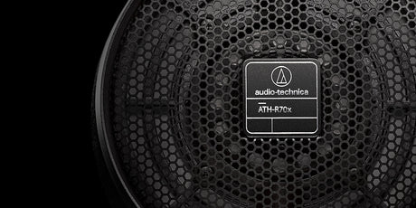 Close-up of Audio-Technica ATH-R70x open-back headphones detailing aluminum mesh earcup grille and Audio-Technica logo