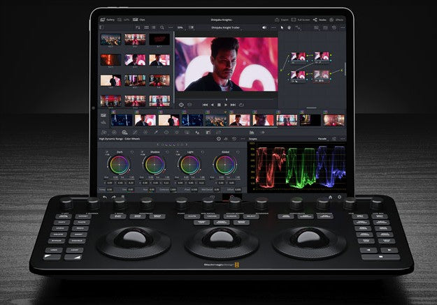 DaVinci Resolve Micro Color Panel with trackballs under a tablet screen displaying color grading interface and video timeline