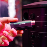 Lifestyle image of Bose S1 Pro+ Wireless Mic/Line Transmitter with an XLR connection, predominantly black in color.