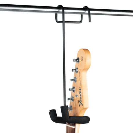 Gator Frameworks GFW-GTRCLOSETHNGR closet hanger yoke in use, supporting Fender electric guitar headstock and neck in black rubberized U-shaped cradle, hooked onto horizontal closet rod with two hangers visible