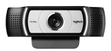 Logitech C930e HD webcam close-up showing lens, logo, and vented housing on black checkered background