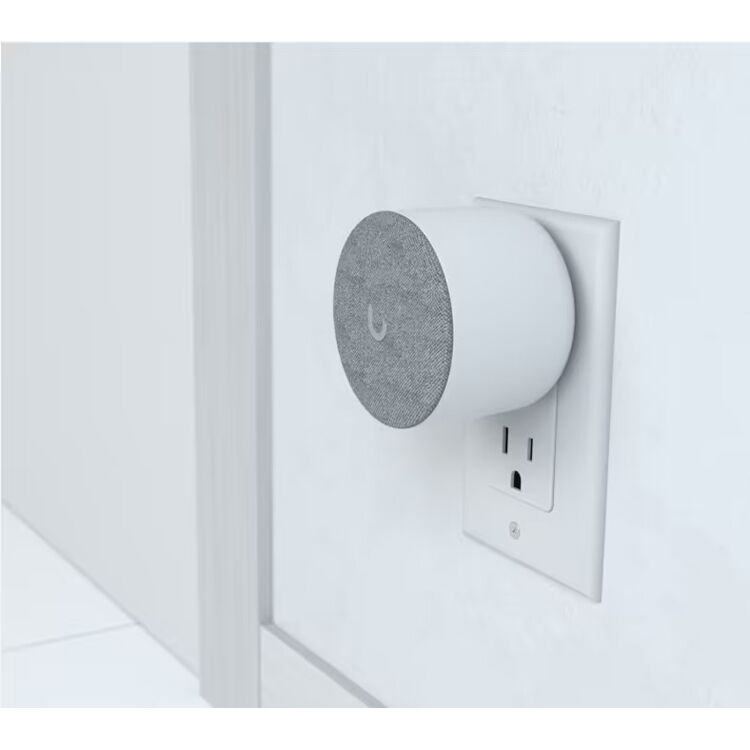 Ubiquiti UniFi Protect WiFi Chime plugged into wall outlet beside UniFi doorbell setup, illustrating real‑world placement and wireless notification integration