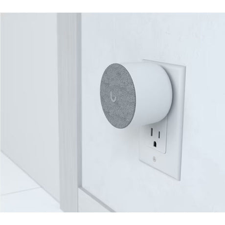 Ubiquiti UniFi Protect WiFi Chime plugged into wall outlet beside UniFi doorbell setup, illustrating real‑world placement and wireless notification integration