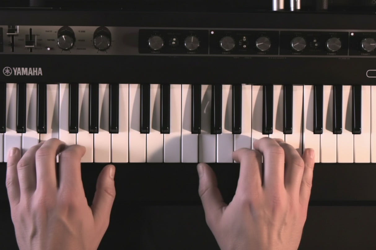 Hands playing Yamaha reface CP mini vintage keyboard with 37 keys and effects knobs