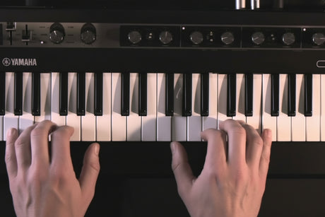 Hands playing Yamaha reface CP mini vintage keyboard with 37 keys and effects knobs